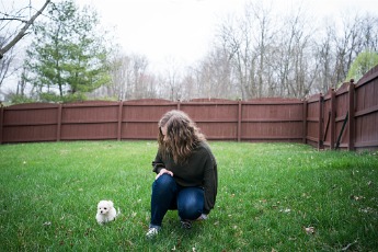 A girl plays with her dog safely in her back yard after America's Backyard, one of the best Fence Companies in Joliet IL, installed privacy fencing in her yard.